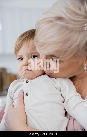 une grand-mère apaisante et une petite fille bouleversée à la maison, image de stock Banque D'Images