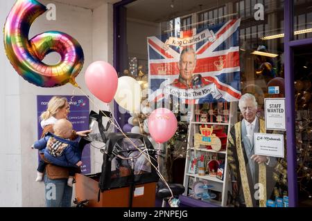 Deux semaines avant le couronnement du roi Charles III, une mère attache des ballons de fête à son vélo de cargaison après les avoir achetés d'une entreprise de fête et de ballon vendant des marchandises royales, le 19th avril 2023, à Londres, en Angleterre. Le roi Charles succédera à la reine Elizabeth II le 6th mai, qui est décédée l'année dernière. Banque D'Images