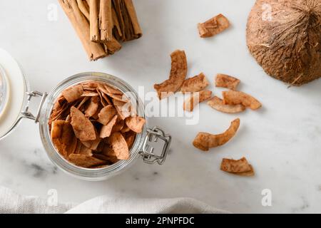 Fruits, copeaux de poire et eau dans une ombre dure ensoleillée sur un fond blanc carrelé. Dessert végétalien sans sucre. Vue de dessus. Copier l'espace. Banque D'Images