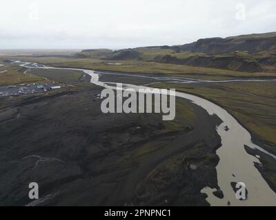 Un plan aérien de la rivière glaciaire près de Solheimajokulll qui s'enroule à travers le champ Banque D'Images