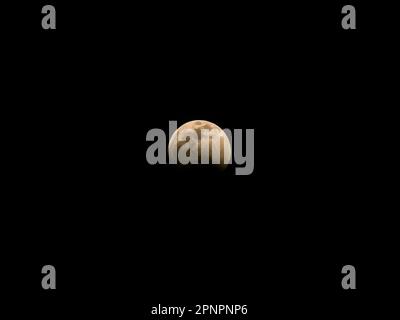 Pleine lune partiellement couverte par des nuages dans le ciel nocturne Banque D'Images