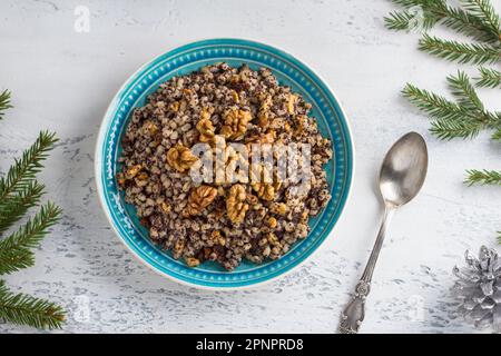 Plat de Noël russe traditionnel Sochivo à base d'orge perlé, de graines de pavot, de noix, de raisins secs et de miel, décoré de branches d'arbres de Noël sur un Banque D'Images