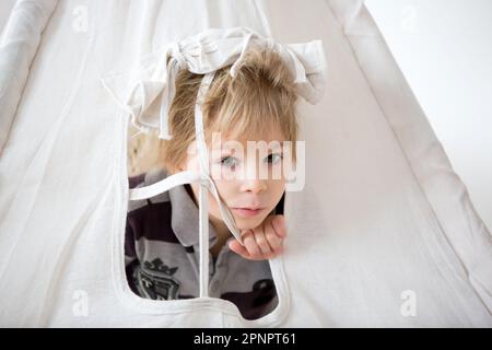 Enfant blond en forme de jeune enfant, portant une tipi avec un singe farci à la maison Banque D'Images