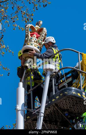 Londres, Royaume-Uni. 20 avril 2023. Les ouvriers installent des couronnes ornementales sur les mâts de drapeaux du Mall, ainsi que d'autres décorations, avant le couronnement du roi Charles III le 6 mai. Les drapeaux syndicaux pendront des mâts de drapeau pendant le couronnement. Credit: Stephen Chung / Alamy Live News Banque D'Images