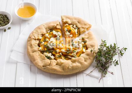 Galette maison avec citrouille, feta, miel, graines de citrouille et thym sur fond blanc, vue du dessus Banque D'Images