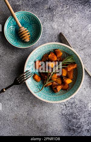 Vue panoramique sur un bol de citrouille rôtie au romarin, au miel et au miel Banque D'Images