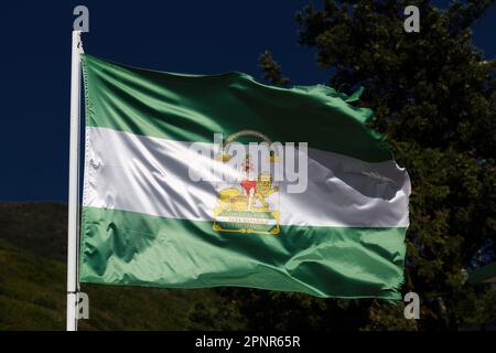 Drapeau de l'Andalousie avec heracles andalou ensign bannière emblème streaming vent devant le paysage de l'espagne Banque D'Images