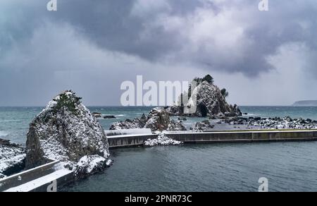 La côte de la mer du Japon en hiver dans la préfecture d'Aomori, vue à partir d'un train sur la ligne Gono. Banque D'Images