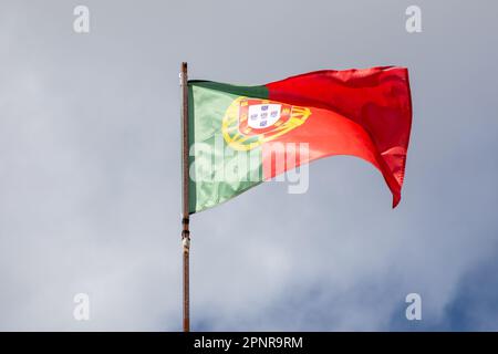 Drapeau du Portugal agitant au-dessus du ciel bleu nuage portugais Banque D'Images
