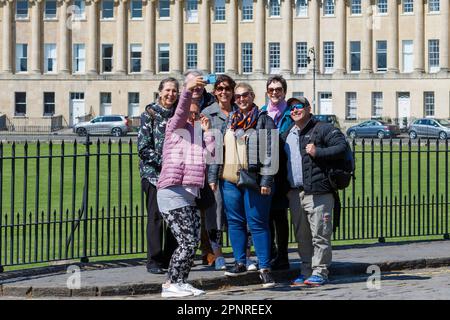 Bath, Royaume-Uni. 20th avril 2023. Les prévisionnistes prédisent que le temps sera plus frais et plus couvert dans les prochains jours, les touristes sont photographiés alors qu'ils prennent un selfie de groupe devant le célèbre Royal Crescent de Bath. Credit: Lynchpics/Alamy Live News Banque D'Images