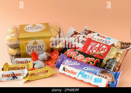 Arahal. Séville. Espagne. 18 mars 2023. Encore la vie avec des chocolats et des chocolats de différentes marques sur fond orange . Consommation excessive de Banque D'Images