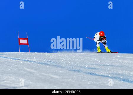 ski sur piste de ski alpin, descente, porte rouge et piste enneigée sur fond de ciel bleu, jeux de sports d'hiver Banque D'Images