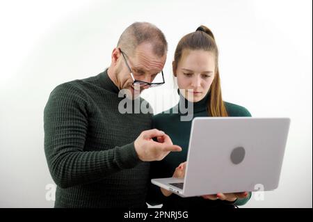 Professeur, responsable ou mentor professionnel aidant un étudiant latin, un nouvel employé, un stagiaire enseignant, expliquant un emploi en ligne à l'aide d'un ordinateur portable, parlant, ayant une discussion de travail d'équipe au bureau. Haute qualité Banque D'Images