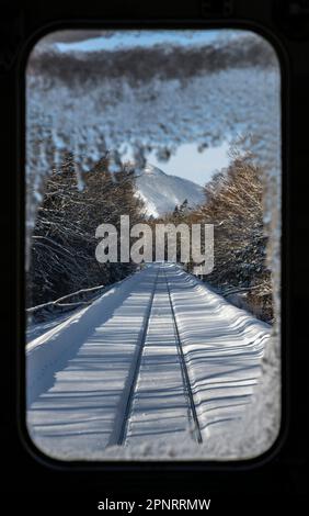 Vue par la fenêtre avant d'un train JR Hokkaido sur la ligne Senmo (ou Semmo) lors d'une journée d'hiver au Japon. Banque D'Images