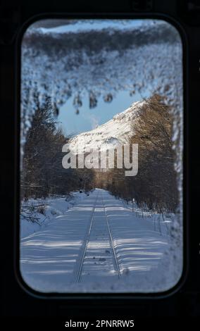 Vue par la fenêtre avant d'un train JR Hokkaido sur la ligne Senmo (ou Semmo) lors d'une journée d'hiver au Japon. Banque D'Images