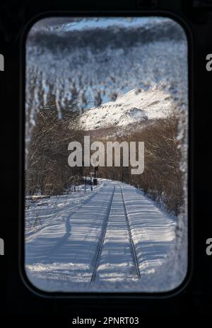 Vue par la fenêtre avant d'un train JR Hokkaido sur la ligne Senmo (ou Semmo) lors d'une journée d'hiver au Japon. Banque D'Images