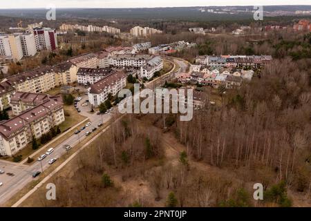 Photographie par drone d'une zone résidentielle entourée de forêt au printemps, jour nuageux Banque D'Images