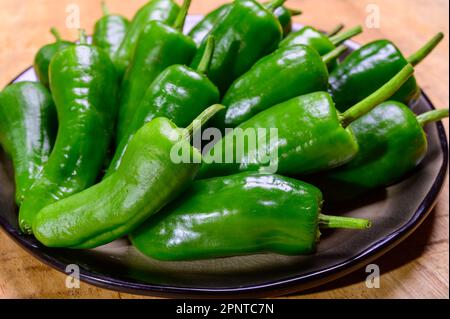 Pementos doux au poivre de padron vert frais, prêts à griller ou à frire avec de l'huile d'olive, en-cas traditionnel en Galice, Espagne. Banque D'Images