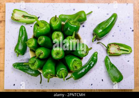 Pementos doux au poivre de padron vert frais, prêts à griller ou à frire avec de l'huile d'olive, en-cas traditionnel en Galice, Espagne. Banque D'Images