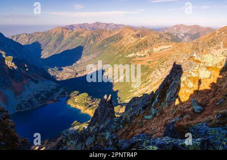 Paysage de montagne avec lac dans la vallée. Silhouette de randonneur sur une colline escarpée dans les montagnes Tatra. Photo prise à Szpiglasowy Wierch Peak à Tatr Banque D'Images