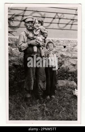 HODONIN, la République tchécoslovaque, vers 1941 : Vintage photo montre les petits enfants avec leur grand-père, vers 1941. Banque D'Images