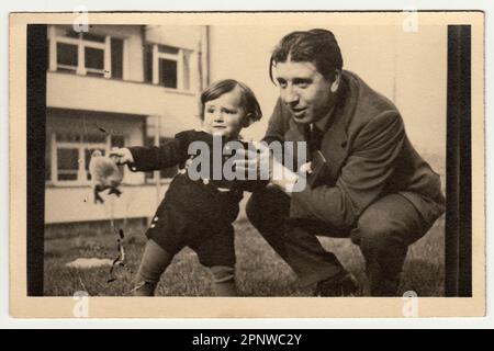 PRAGUE, RÉPUBLIQUE SOCIALISTE TCHÉCOSLOVAQUE - VERS 1950s: Photo d'époque montre père avec enfant et peluche - animal farci. Banque D'Images