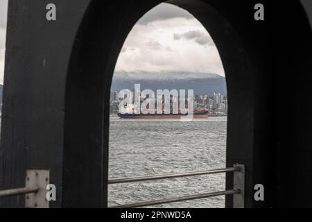 On voit un cargo, devant un pluvieux Vancouver-Nord, à partir du sentier côtier du parc Stanley, à Vancouver, en Colombie-Britannique, au Canada Banque D'Images