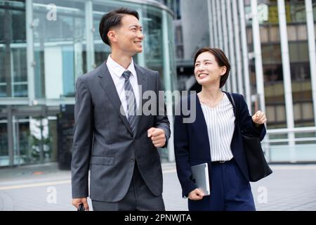 Femme d'affaires et homme d'affaires marchant avec la conversation Banque D'Images