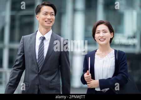 Femme d'affaires et homme d'affaires marchant avec la conversation Banque D'Images