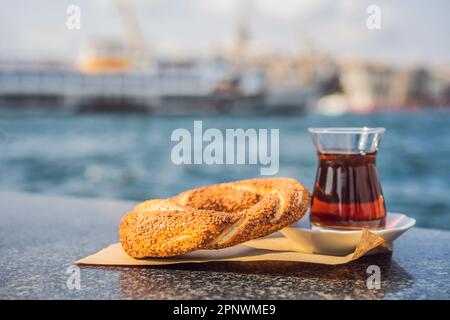 Un verre de thé turc et de bagel simit contre la baie de corne dorée à Istanbul, en Turquie. Turkiye Banque D'Images