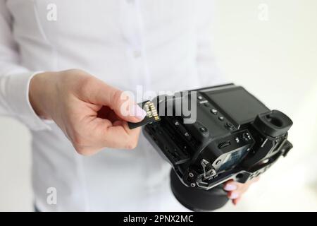 Une jeune femme blogueuse prépare l'appareil photo pour le tournage de vidéos Banque D'Images