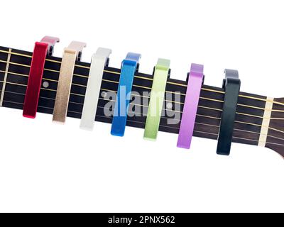 capo coloré sur le fingerboard de guitare, fond blanc, gros plan Banque D'Images