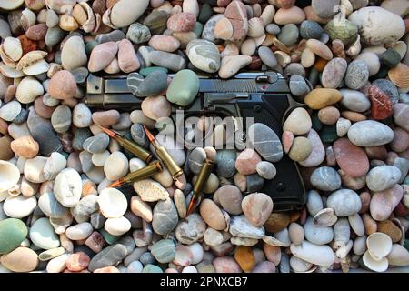 Un pistolet arrosé de petits cailloux sur une plage en début de matinée Banque D'Images