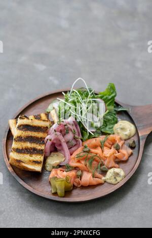 plateau de saumon gralax avec salade et toasts sur fond gris en suède Banque D'Images