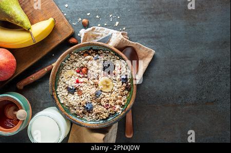 Un bol de granola et de muesli secs servi avec des fruits frais. Petit-déjeuner à l'avoine. Alimentation saine, alimentation. Vue de dessus. Banque D'Images