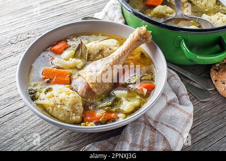 Soupe de poulet fraîche avec boulettes de légumes et de semoule sur une table en bois Banque D'Images