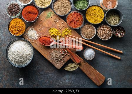 Herbes et épices colorées pour cuisiner des plats asiatiques. Épices et ingrédients chinois sur fond de pierre grise. Vue de dessus. Banque D'Images