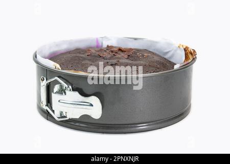 Faire un gâteau dans une forme ronde de gâteau en aluminium isolée sur fond blanc. Tarte maison fraîche dans un plat spécial. Banque D'Images