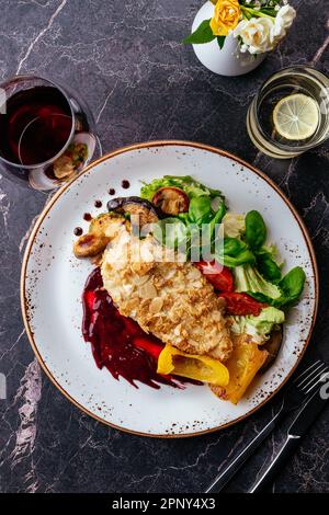 schnitzel de poulet sur une assiette de légumes et de sauce. restaurant Banque D'Images