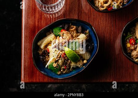 Riz chinois frit avec du calamar, des légumes et des herbes. restaurant Banque D'Images