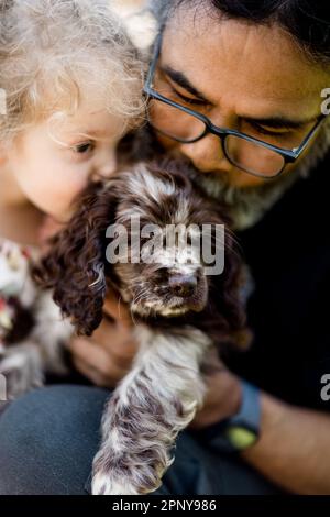 Oncle et nièce Kissing Puppy à San Diego Banque D'Images