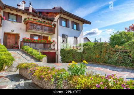 Vue magnifique sur les maisons alpines traditionnelles avec des fleurs sur le balcon de la ville de Cles. Lieu: Clès, région du Trentin-Haut-Adige, Italie, Europe Banque D'Images