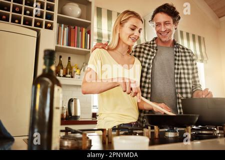 Mes favoris. un couple cuisant un repas ensemble à la maison. Banque D'Images