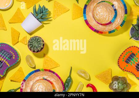 Décor mexicain de vacances Cinco de Mayo avec cactus mexicains, chips de nachos, guitares, chapeau de sombrero et piment, plat jaune vif avec tradi Banque D'Images