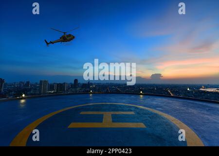 Stationnement en hélicoptère sur le toit d'un gratte-ciel avec vue panoramique au coucher du soleil Banque D'Images