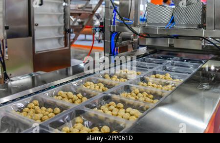 Beaucoup de boulettes de viande chaîne de production alimentaire sur les machines de tapis de convoyeur dans l'usine, la production alimentaire industrielle Banque D'Images