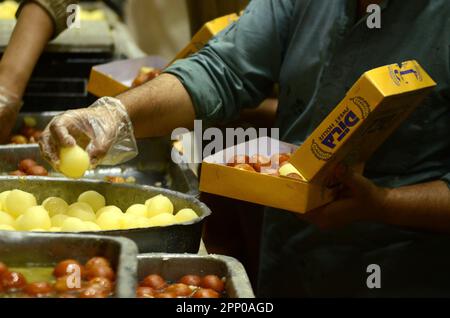 Peshawar, Khyber Pakhtunkhwa, Pakistan. 20th avril 2023. Les gens achètent des bonbons traditionnels en préparation pour les prochaines fêtes d'Eid al-Fitr dans une boutique de Peshawar. L'EID al-Fitr marque la fin du mois Saint islamique du Ramadan. (Credit image: © Hussain Ali/Pacific Press via ZUMA Press Wire) USAGE ÉDITORIAL SEULEMENT! Non destiné À un usage commercial ! Banque D'Images