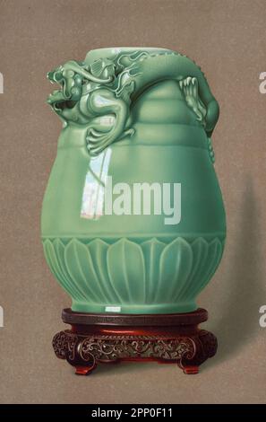 VASE CELADON VERT POIS. (Tsun) de forme et de design anciens, modélisés avec une bande de pétales de lotus qui s'élèvent légèrement autour du pied, et avec trois côtes proéminentes entourant la partie supérieure. Sur l'épaule est accroupi la forme monstrueuse d'un dragon, travaillé en relief saillant et en sous-dépouille, la pièce peut. Peut-être, soit le règne de Yung-cheng (1723-35). Tiré du livre ' LA COLLECTION D'ART CÉRAMIQUE ORIENTALE DE William Thompson Walters ' publié en 1897 Banque D'Images