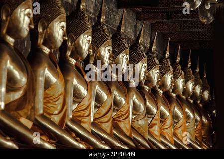 Bouddha d'or à côté de vieux murs dans les temples thaïlandais Banque D'Images