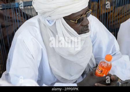 MALI, Gao, village BAGOUNDJÉ, homme porte un casque blanc Boubou et Tagelmust, tenant une boisson gazeuse en bouteille plastique / Dorf BAGOUNDJÉ, Mann mit traditionellem Gewand Boubou und Tagelmust Kopfbematelung Banque D'Images